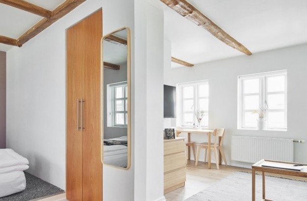 Open-plan space with cozy bedroom corner and light-filled dining space at Thingholt apartments from Center Hotels.