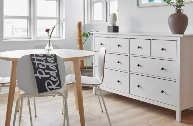 Bright dining area with round table, white chairs, and large windows at Thingholt apartments from Center Hotels in Reykjavik.