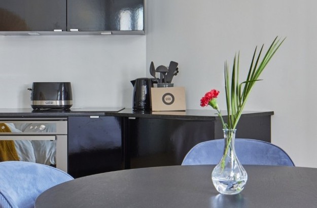 Black kithcenette with modern appliances and a toaster in the family apartment at Thingholt apartments from Center Hotels.