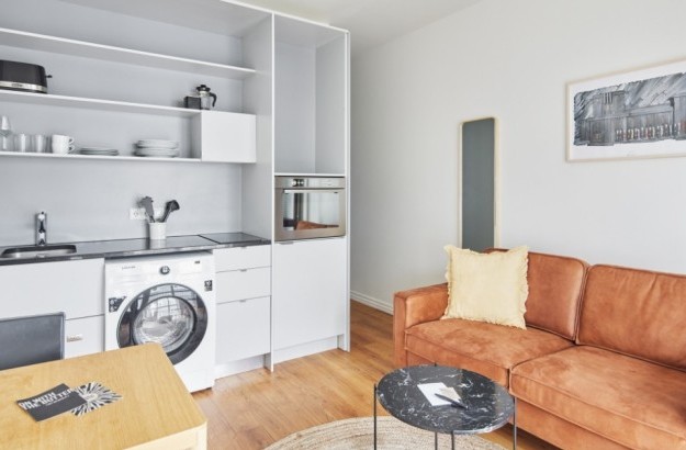 Modern one-bedroom apartment with open kitchen, sofa, and dining space at Thingholt apartments from Center Hotels in Reykjavik.