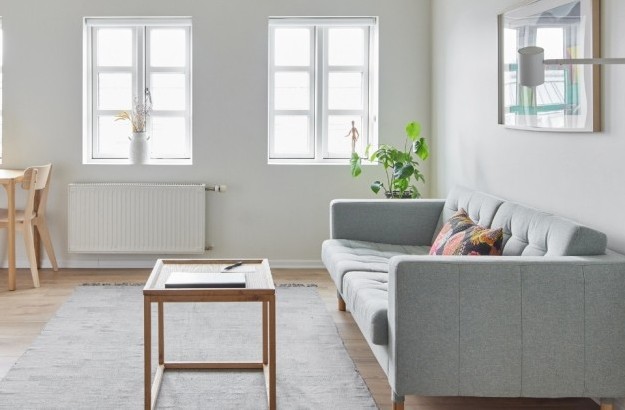 Modern living room with light wood furniture and soft grey sofa at Thingholt apartments by Center Hotels in Reykjavik.