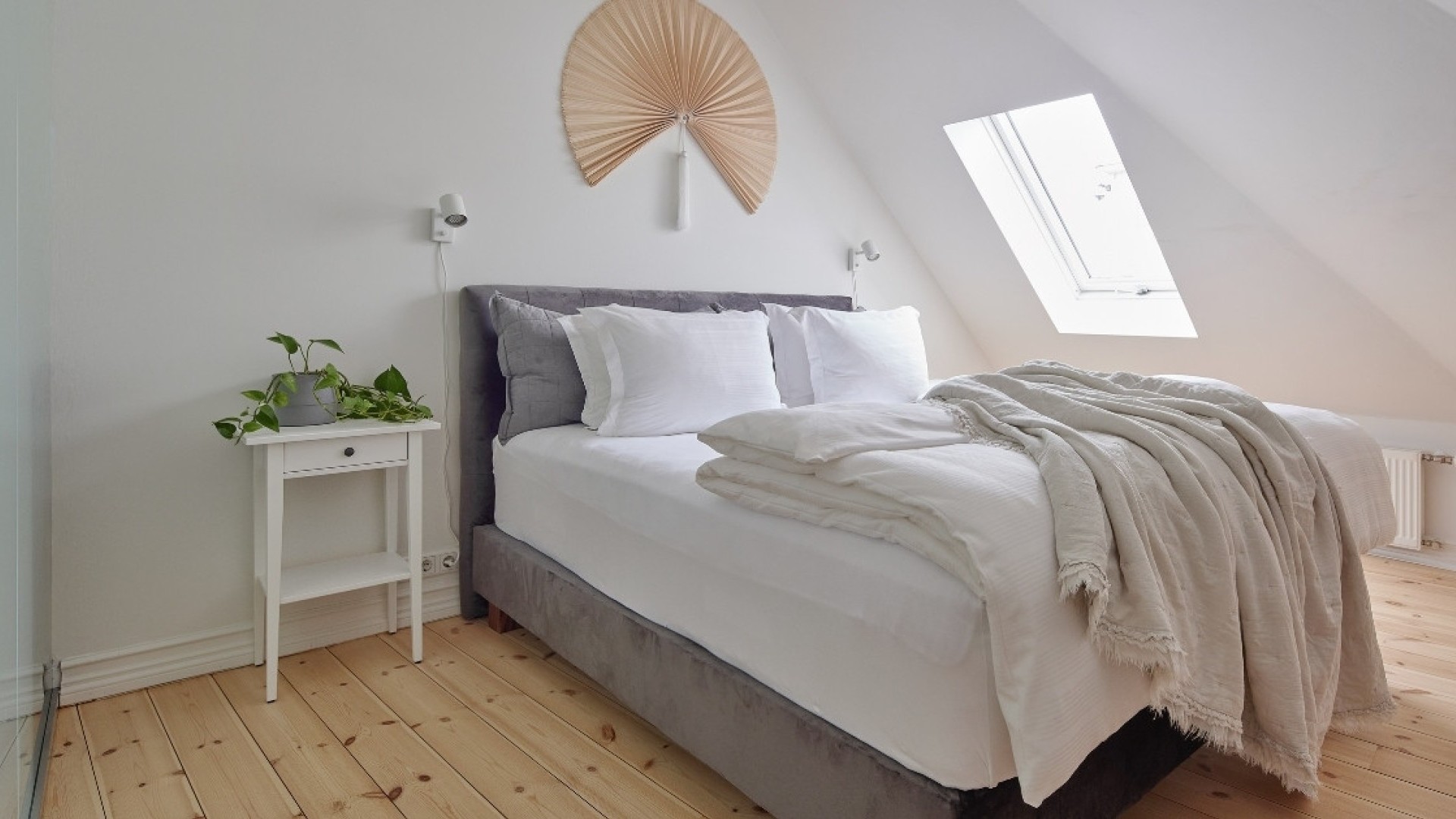 Bright superior apartment bedroom area with skylight and cozy bedding at Thingholt apartments from Center Hotels in Reykjavik.