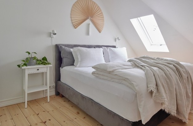 Bright superior apartment bedroom area with skylight and cozy bedding at Thingholt apartments from Center Hotels in Reykjavik.