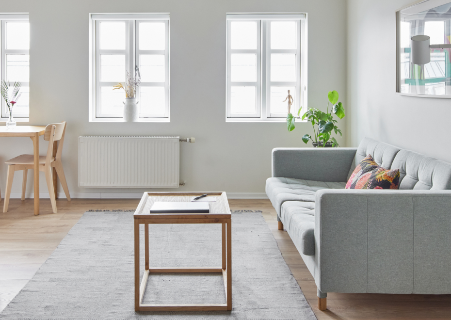 Modern living room with light wood furniture and soft grey sofa at Thingholt apartments by Center Hotels in Reykjavik.