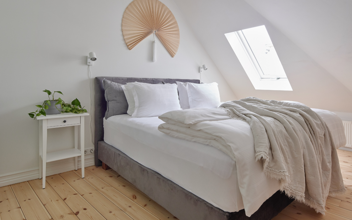Bright superior apartment bedroom area with skylight and cozy bedding at Thingholt apartments from Center Hotels in Reykjavik.