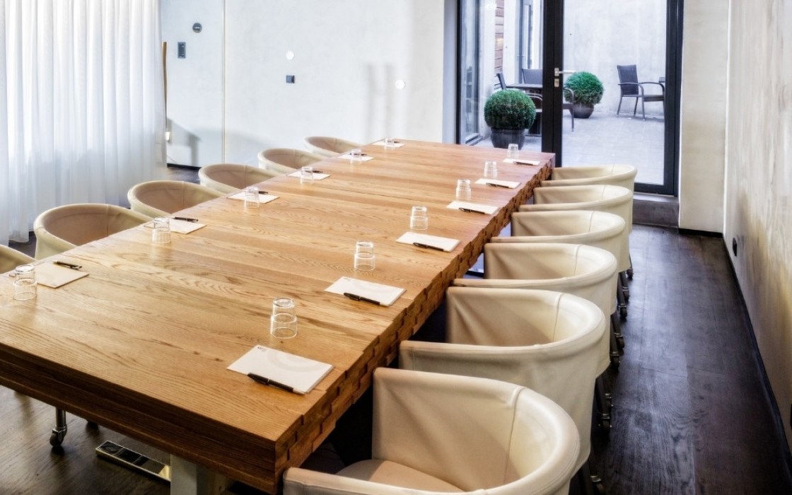 isafold Meeting Room at Thingholt by Center Hotels in Reykjavík featuring a long natural wood conference table, modern cream chairs on casters, notepads and glasses arranged for a meeting, wi