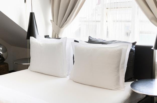 A picture of the bed in a standard room at Thingholt by Center Hotels with white linen and black nightstands