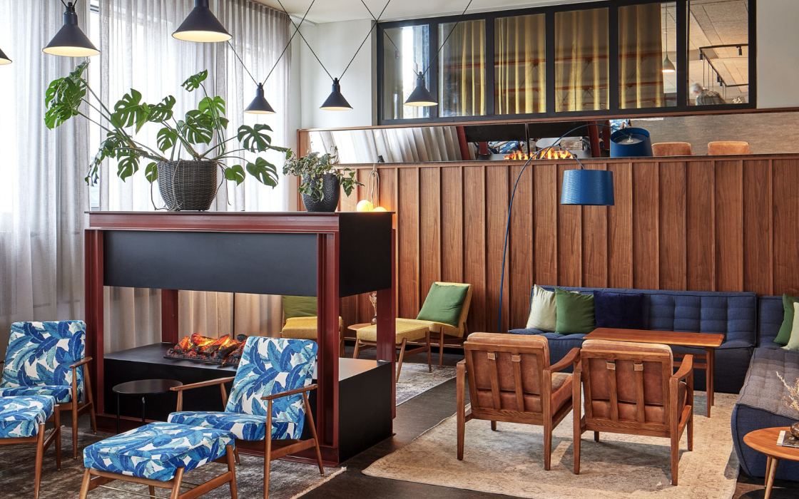 Stylish and cozy hotel lounge at Grandi by Center Hotels in Reykjavik, Iceland, featuring colorful seating, a modern fireplace, and Scandinavian design.