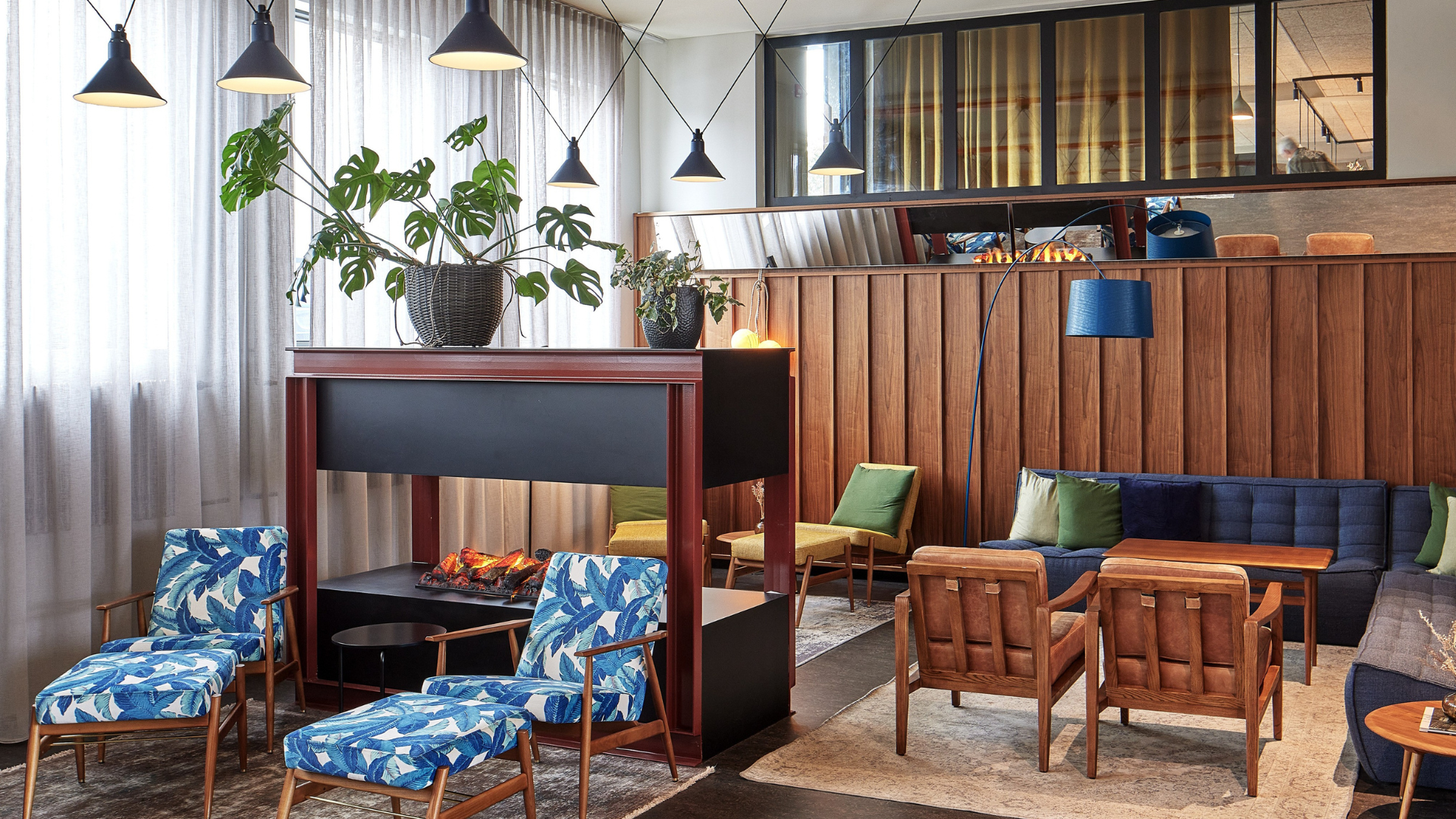 Stylish and cozy hotel lounge at Grandi by Center Hotels in Reykjavik, Iceland, featuring colorful seating, a modern fireplace, and Scandinavian design.