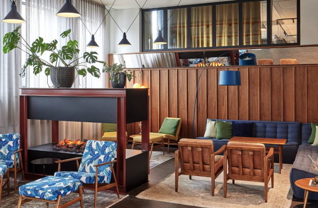 Stylish and cozy hotel lounge at Grandi by Center Hotels in Reykjavik, Iceland, featuring colorful seating, a modern fireplace, and Scandinavian design.