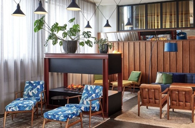 Stylish and cozy hotel lounge at Grandi by Center Hotels in Reykjavik, Iceland, featuring colorful seating, a modern fireplace, and Scandinavian design.