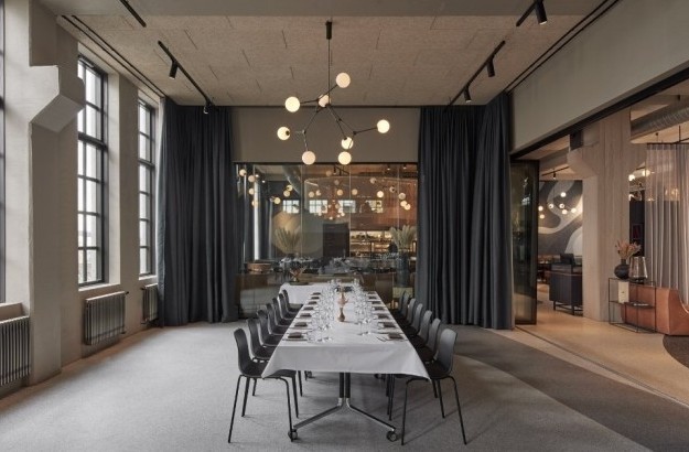 Versatile meeting space at Grandi by Cente rHotels with long table, modern lighting, and flexible layout connected to restaurant and lounge areas.