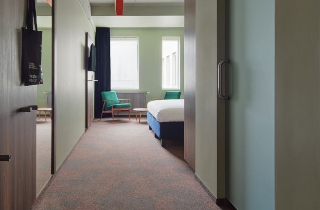 View from the hallway into the deluxe king room at Grandi by Center Hotels in Reykjavik with minimalist decor.