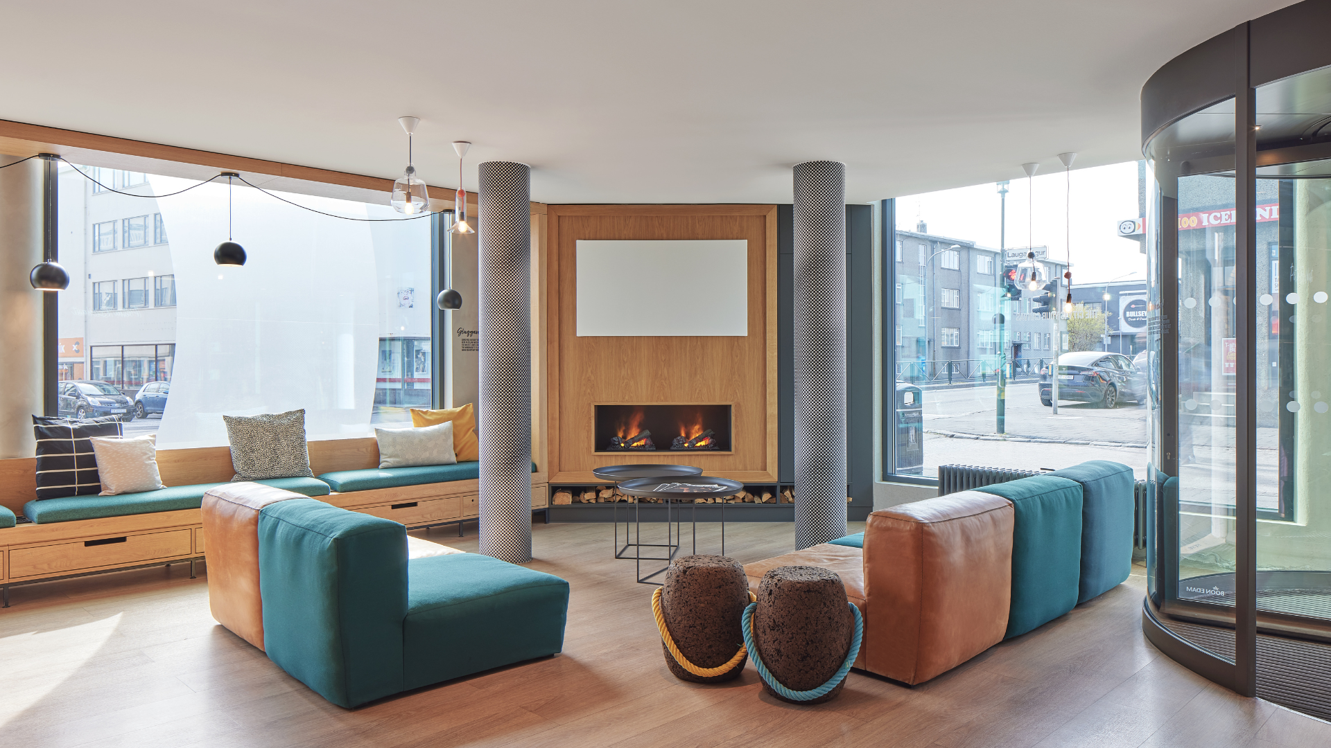 Hotel lounge at Center Hotels Laugavegur in Reykjavik. Includes colorful seating, large street facing windows, and a fireplace.