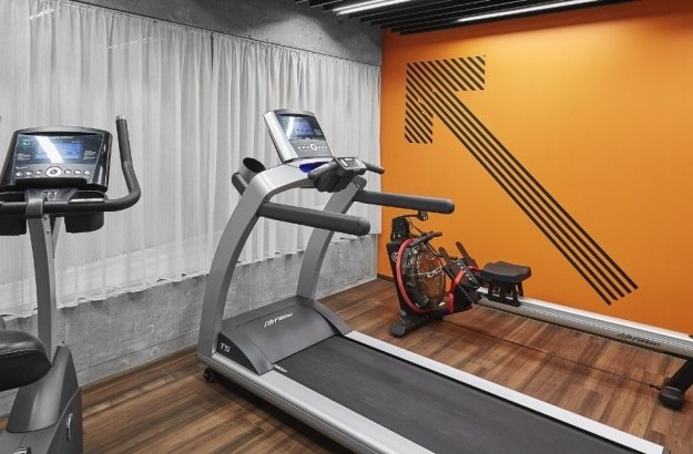 Fitness room at Midgardur by Center Hotelsin Reykjavik with a treadmill, bike, and a rowing machine.