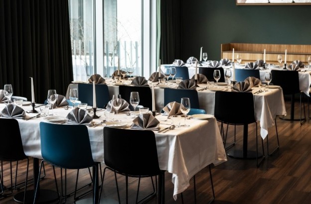 midgardur-centerhotels-reykjavik-venue-event-setup Alt: Elegant venue space at Midgardur by Center Hotels in Reykjavik set up for a formal event with folded napkins, candles, and glassware.
