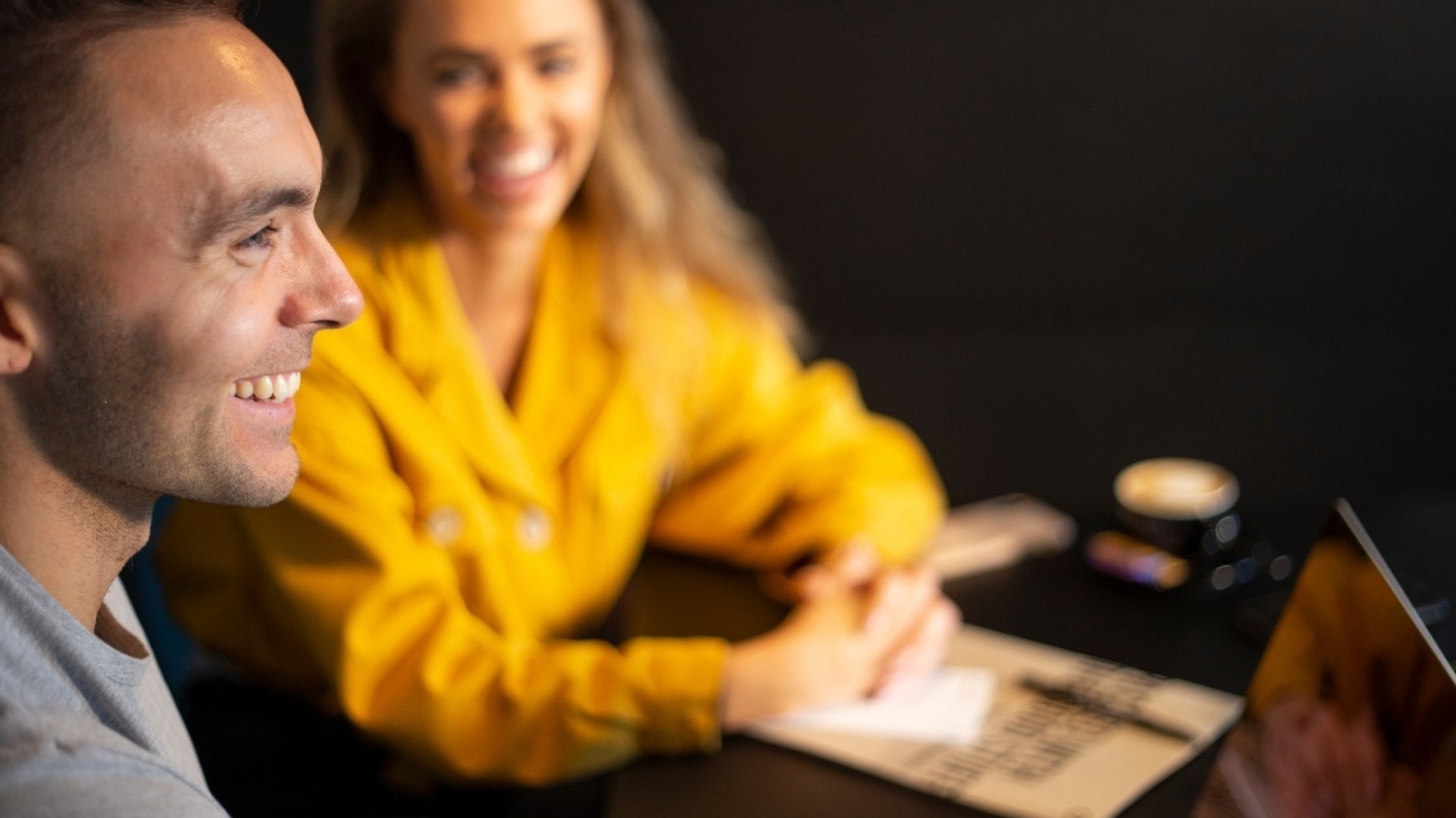 Smiling guests with laptop and coffee in a meeting at Midgardur by Center Hotels in Reykjavik.