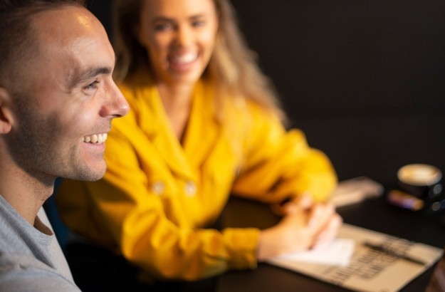 Smiling guests with laptop and coffee in a meeting at Midgardur by Center Hotels in Reykjavik.