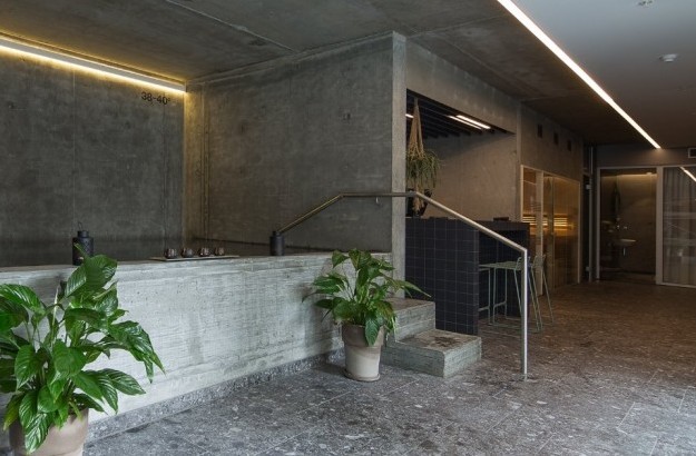 Stylish spa interior at Midgardur with indoor hot tub, lounge seating, and potted plants.