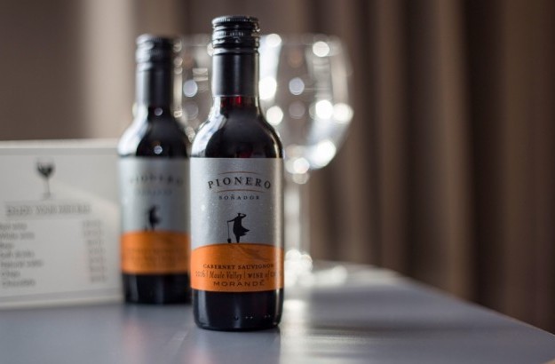 Two miniature wine bottles and glasses on a table in the standard room at Midgardur by Center Hotels in Reykjavik.