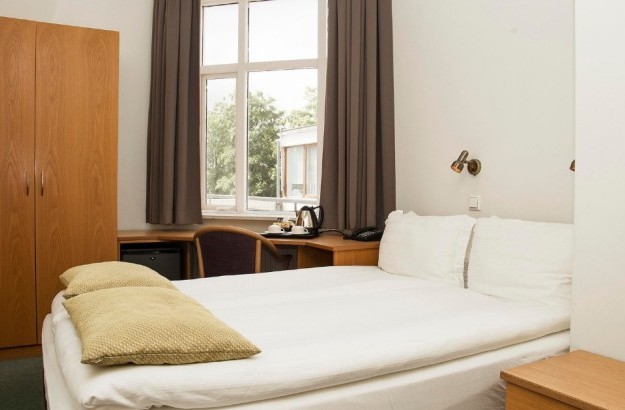 Superior single room at Center Hotels Skjaldbreid in Reykjavik, featuring a bed, window with a view, wardrobe, desk, and in-room tea and coffee station.