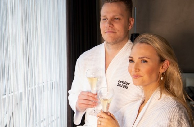 A couple enjoying a glass of champagne in bathrobes at Thingholt by Center Hotels in Reykjavik.