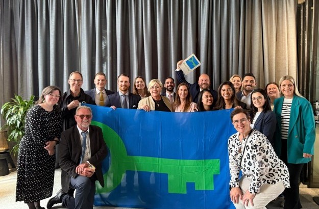 Hópur af fólki sem stendur fyrir aftan stóra fána merktan græna lyklinum og heldur á öðrum minni græna lykils fána center hotels reykjavík Ísland