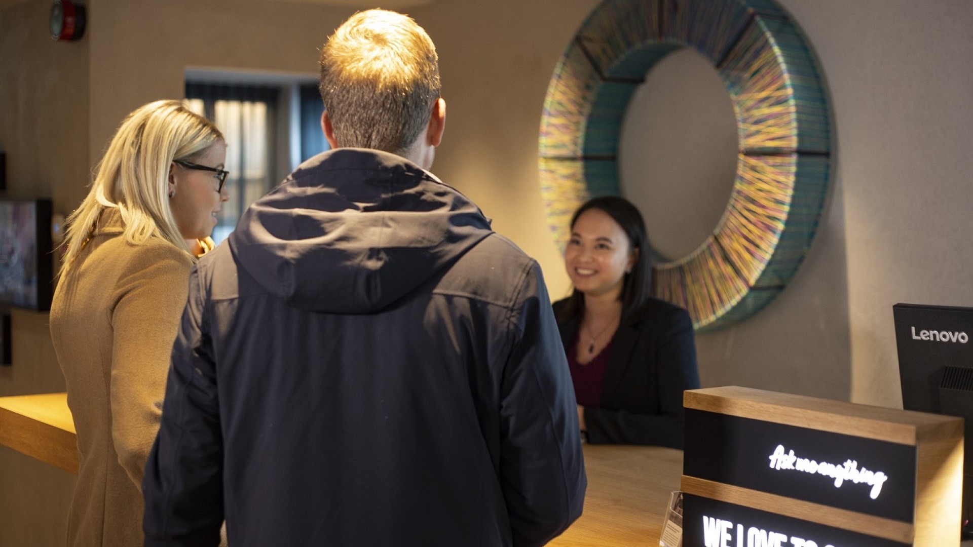 A Center Hotels staff member checking customers into the hotels. Standing in front of a circle