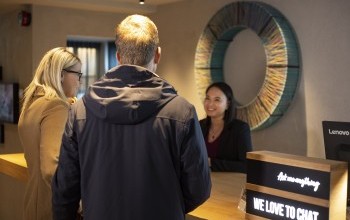 A Center Hotels staff member checking customers into the hotels. Standing in front of a circle
