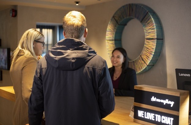 A Center Hotels staff member checking customers into the hotels. Standing in front of a circle