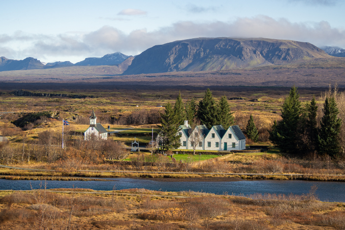 Þingvellir national park in the winter time. The church and houses in Þingvellir visible as well as the mountain range behind.