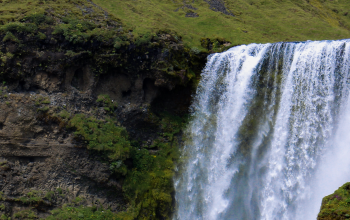A large waterfall in with powerful water stream in the summer time in the south coast of Icelanc