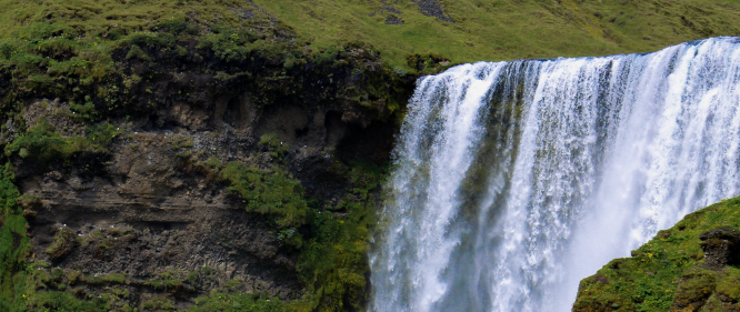 A large waterfall in with powerful water stream in the summer time in the south coast of Icelanc