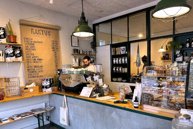 Interior of a cozy Reykjavík coffee shop with pastries, espresso machine, and seating area