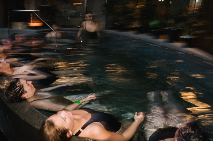 Guests relaxing in a geothermal spa pool at night in Reykjavík