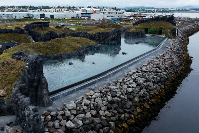 Aerial view of Sky Lagoon geothermal infinity pool along the ocean near Reykjavik.
