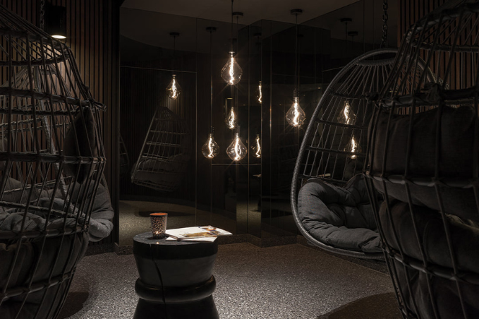 Spa lounge with hanging chairs and warm pendant lights at Hreyfing spa in Reykjavik.