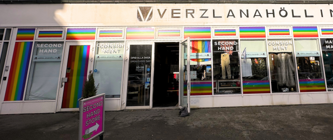 Front view of Verzlanahöllin thrift shop in Reykjavík with rainbow decorations and secondhand clothes in the window.