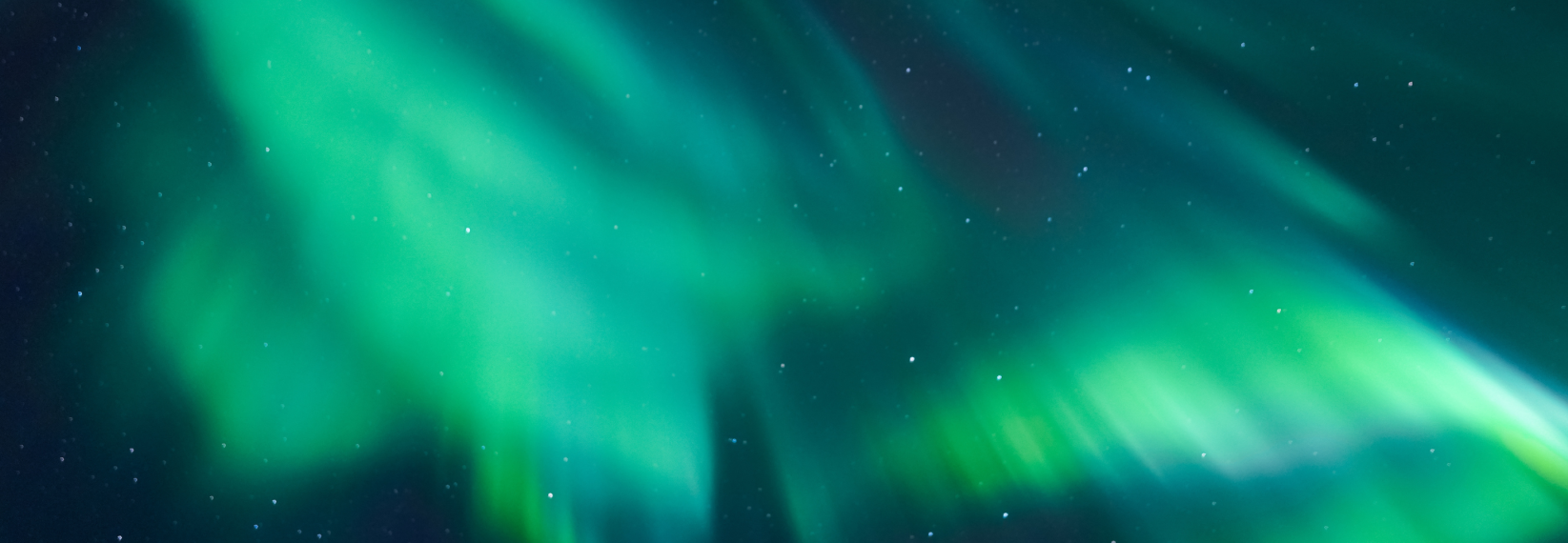 Green northern lights glowing across a starry night sky in Iceland.