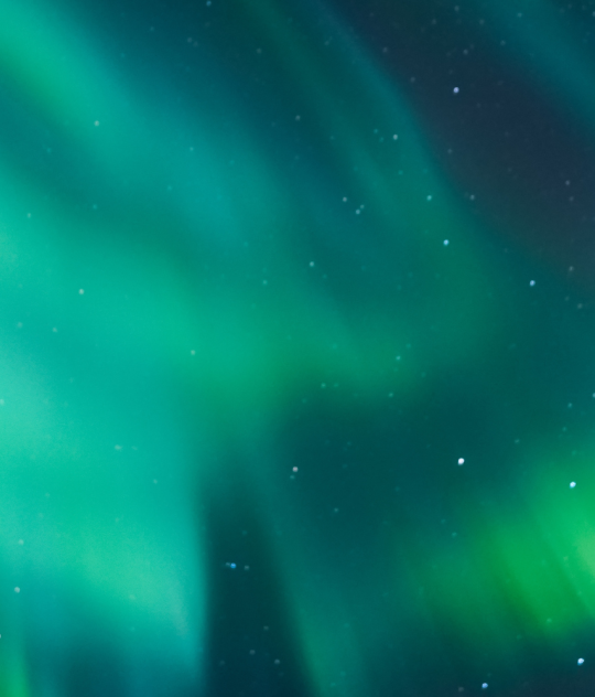 Green northern lights glowing across a starry night sky in Iceland.