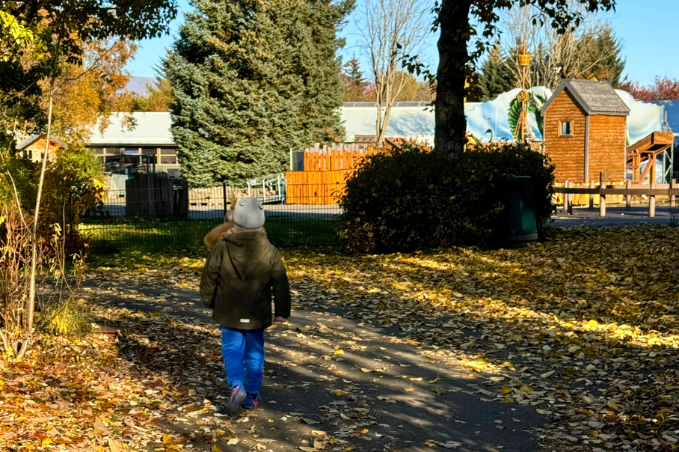 Child walking toward a playground on an autumn day in Reykjavík, Iceland