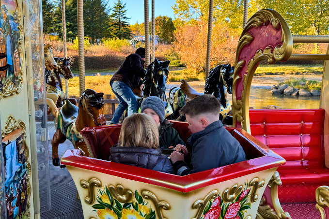 Families enjoying a carousel at Reykjavík Family Park and Zoo in Iceland