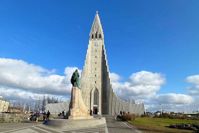 Hallgrímskirkja church and the Leif Erikson statue under a blue sky in Reykjavík.