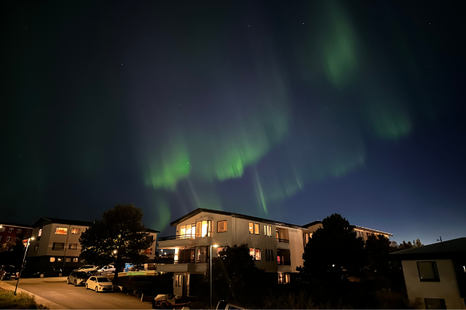 Northern Lights glowing over Reykjavik on a clear night