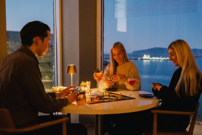 Guests enjoying drinks at SKÝ Lounge & Bar with views over Reykjavík.