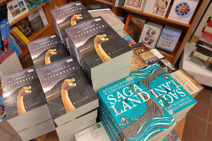 Stacks of The Sagas of Icelanders and Saga Land displayed alongside other books in a Reykjavík bookshop.