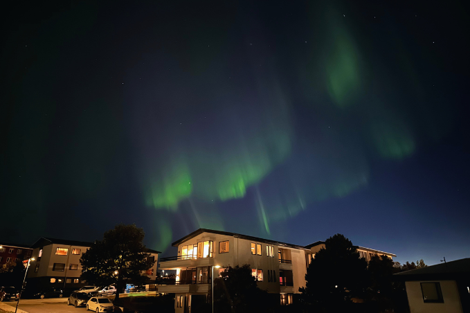 Northern Lights dancing over houses in Hafnarfjörður, Iceland
