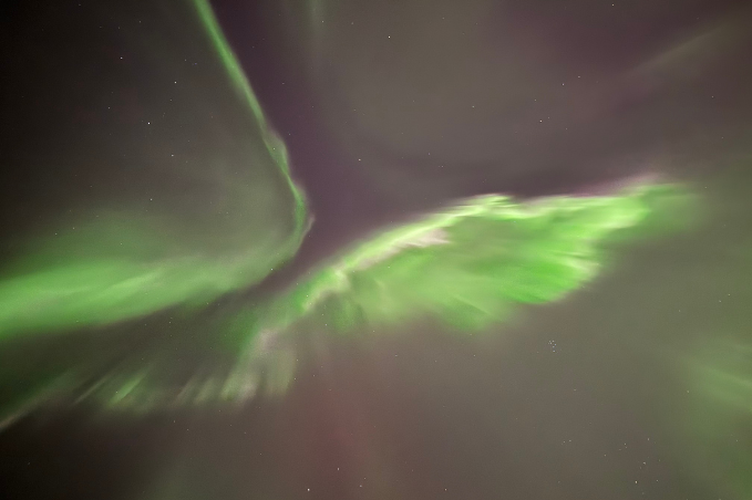 Green aurora borealis dancing across the night sky above Iceland.