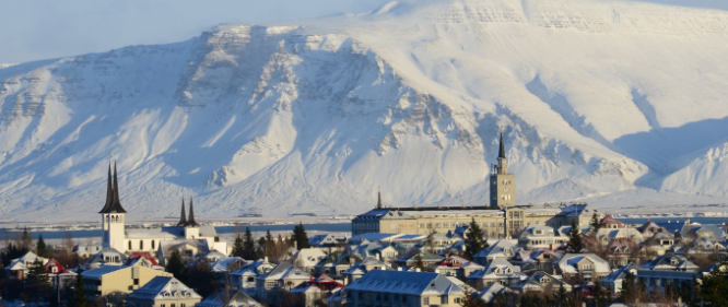 Reykjavik in the winter time with snow in the mountain. Overview over the city center with houses visible.