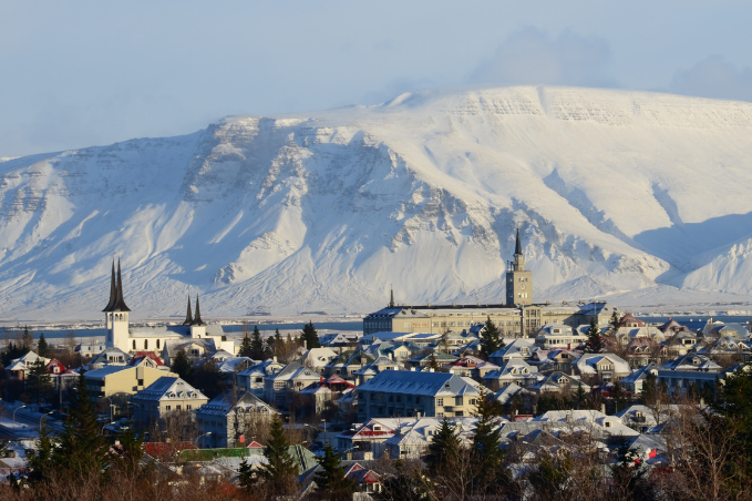 Reykjavik in the winter time with snow in the mountain. Overview over the city center with houses visible.